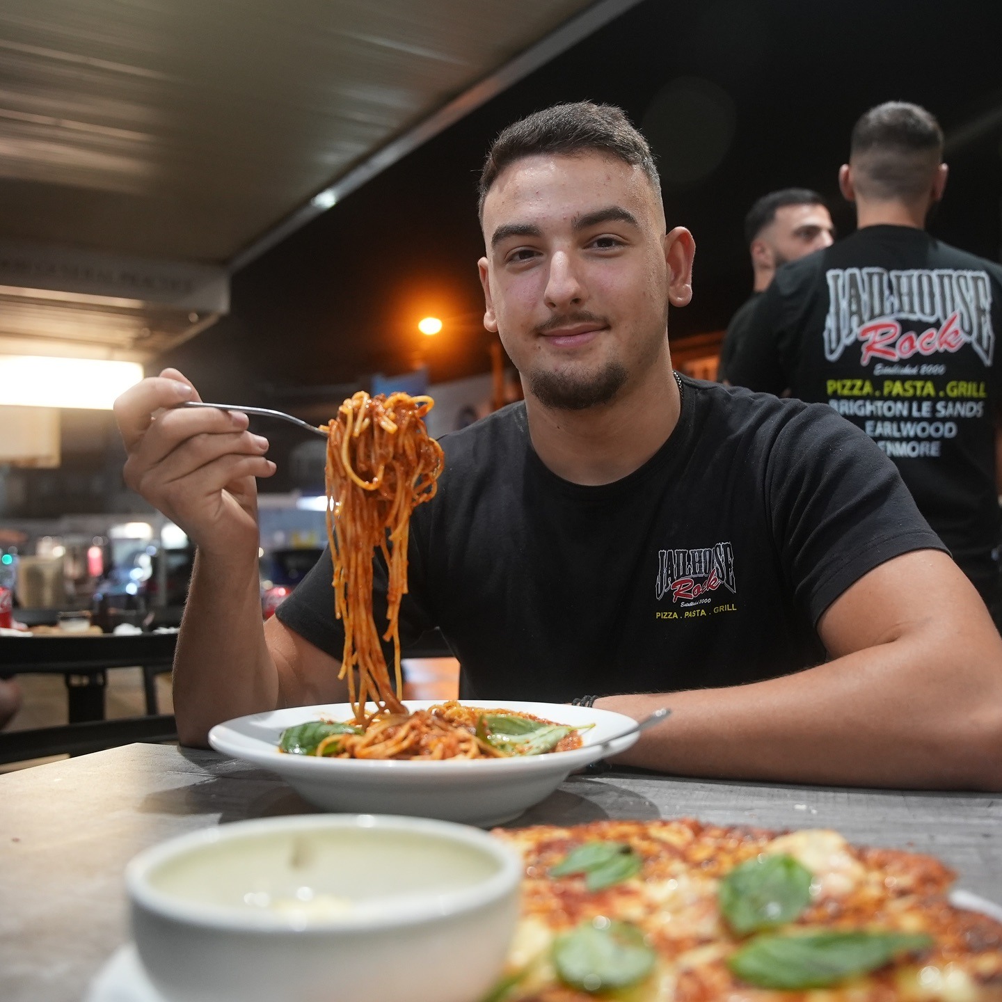 Guest twirling spaghetti in a Jailhouse Rock tee